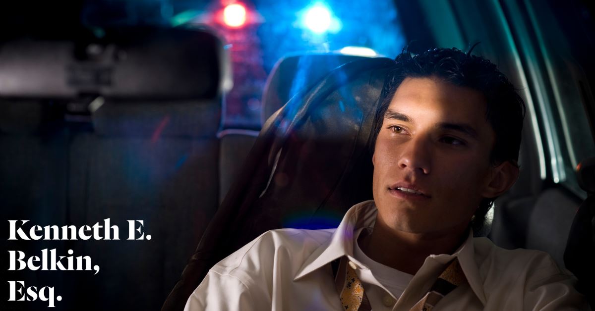 young male driver seeing police lights behind him