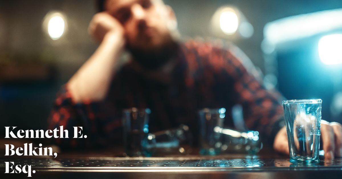 man with empty shot glasses at a bar