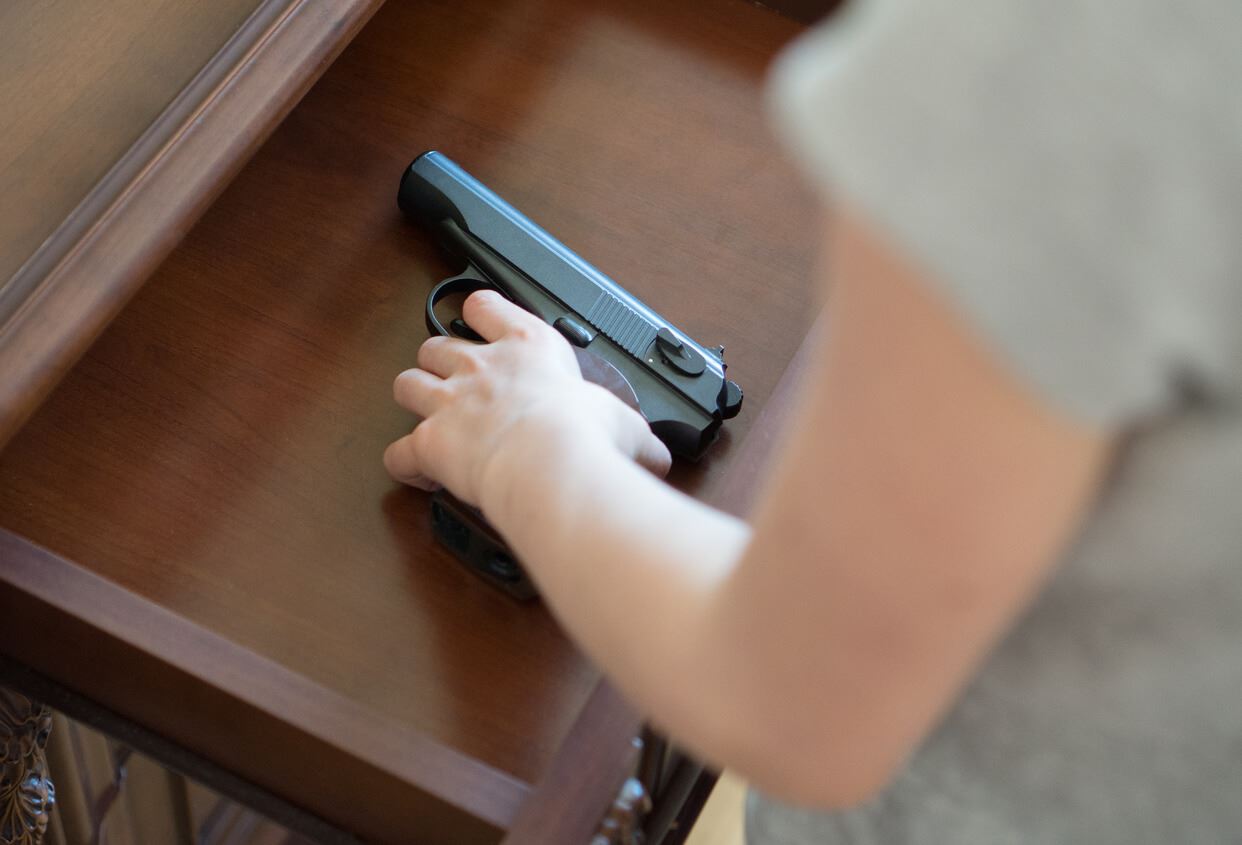 Woman putting gun in drawer